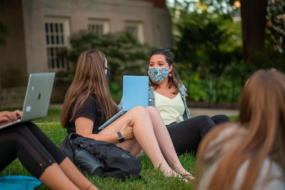 students sitting on the lawn socializing distanced